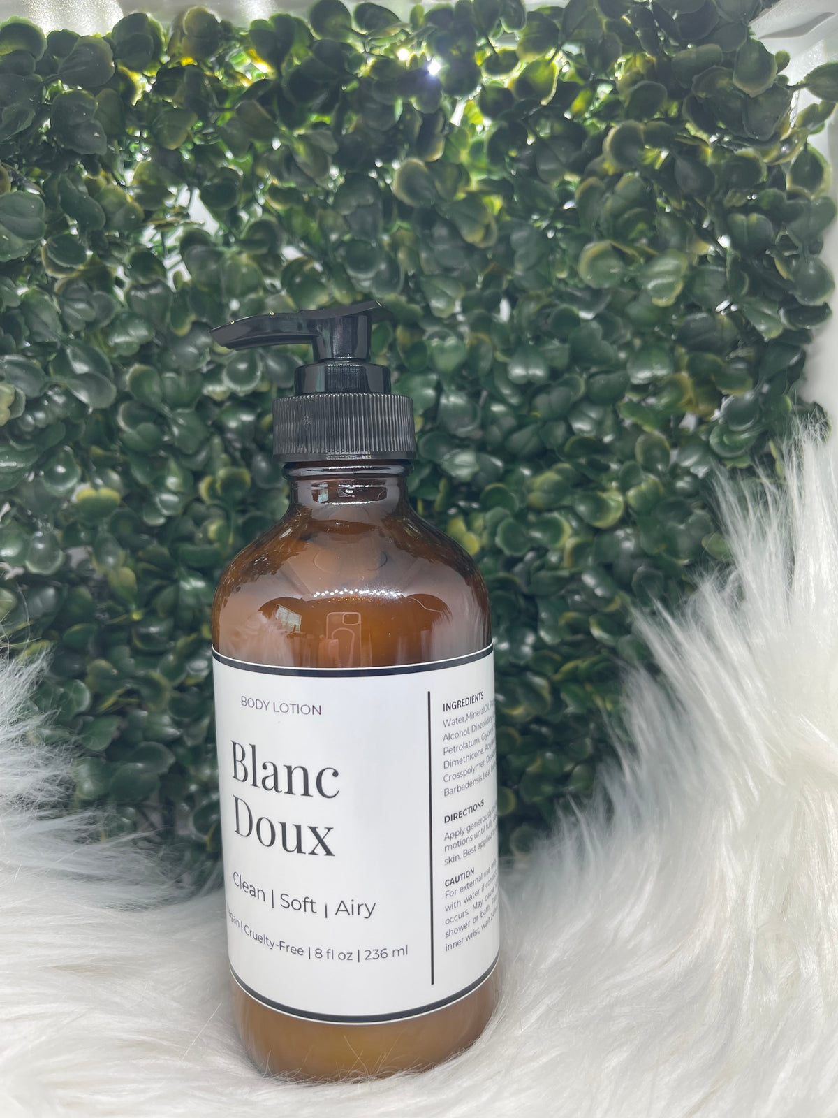 Bottle of Blanc Doux product on a textured green and white background