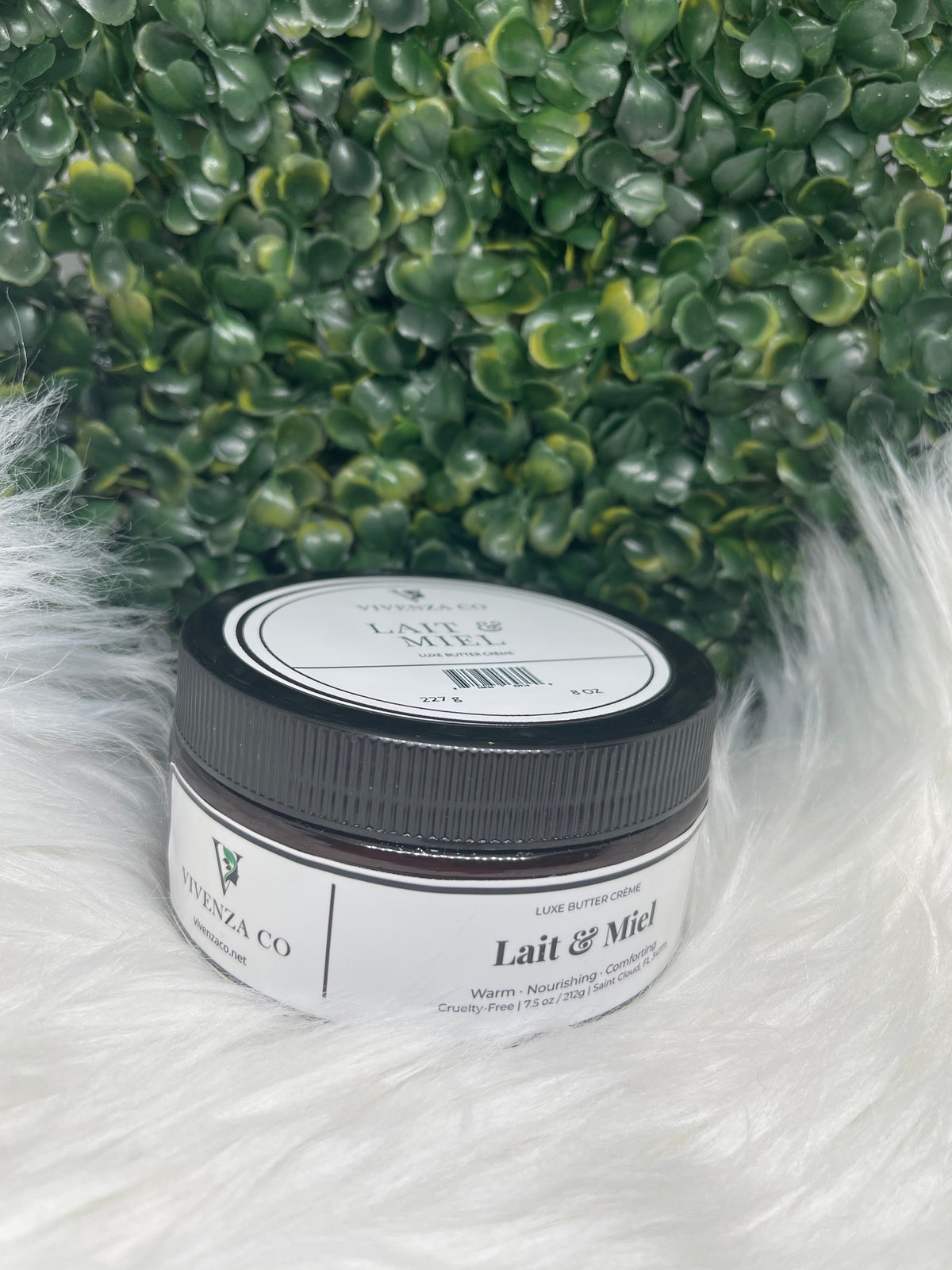 Jar of cream with a label on a textured white and green background