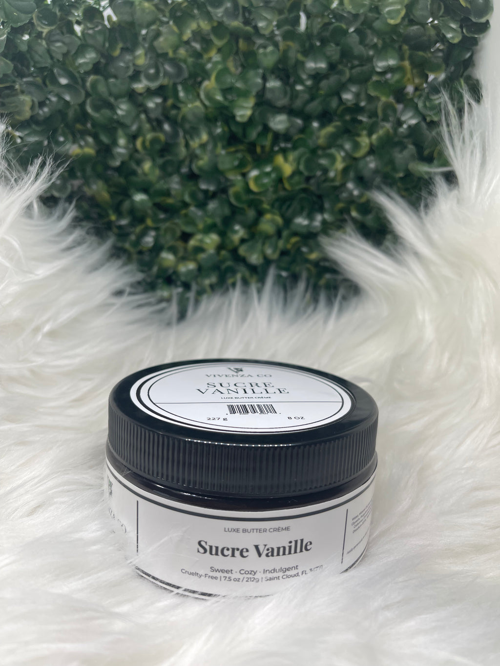 Jar of Sucre Vanille on a fluffy white surface with greenery in the background