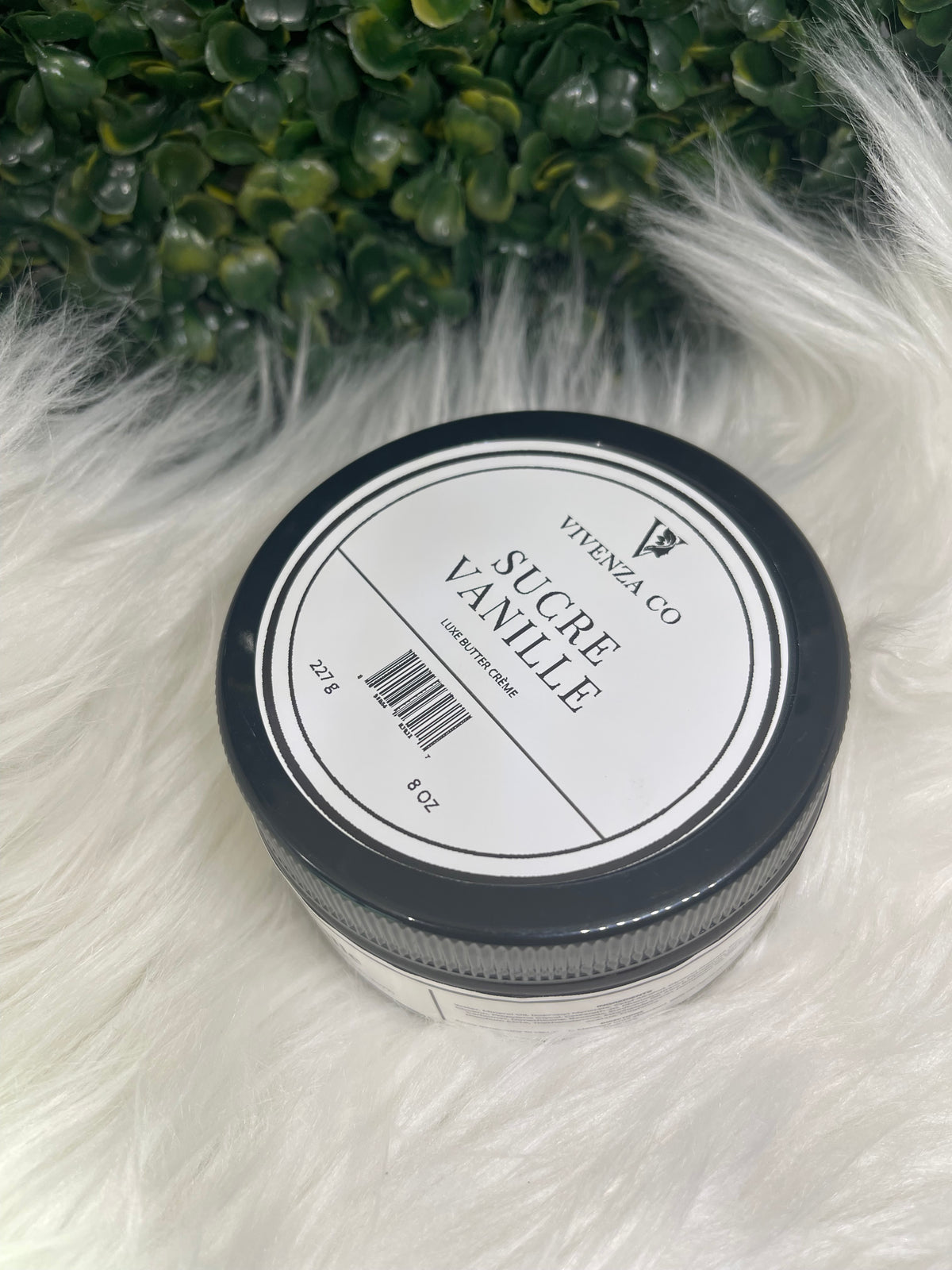 Jar of sucre vanille on a fluffy white surface with greenery in the background