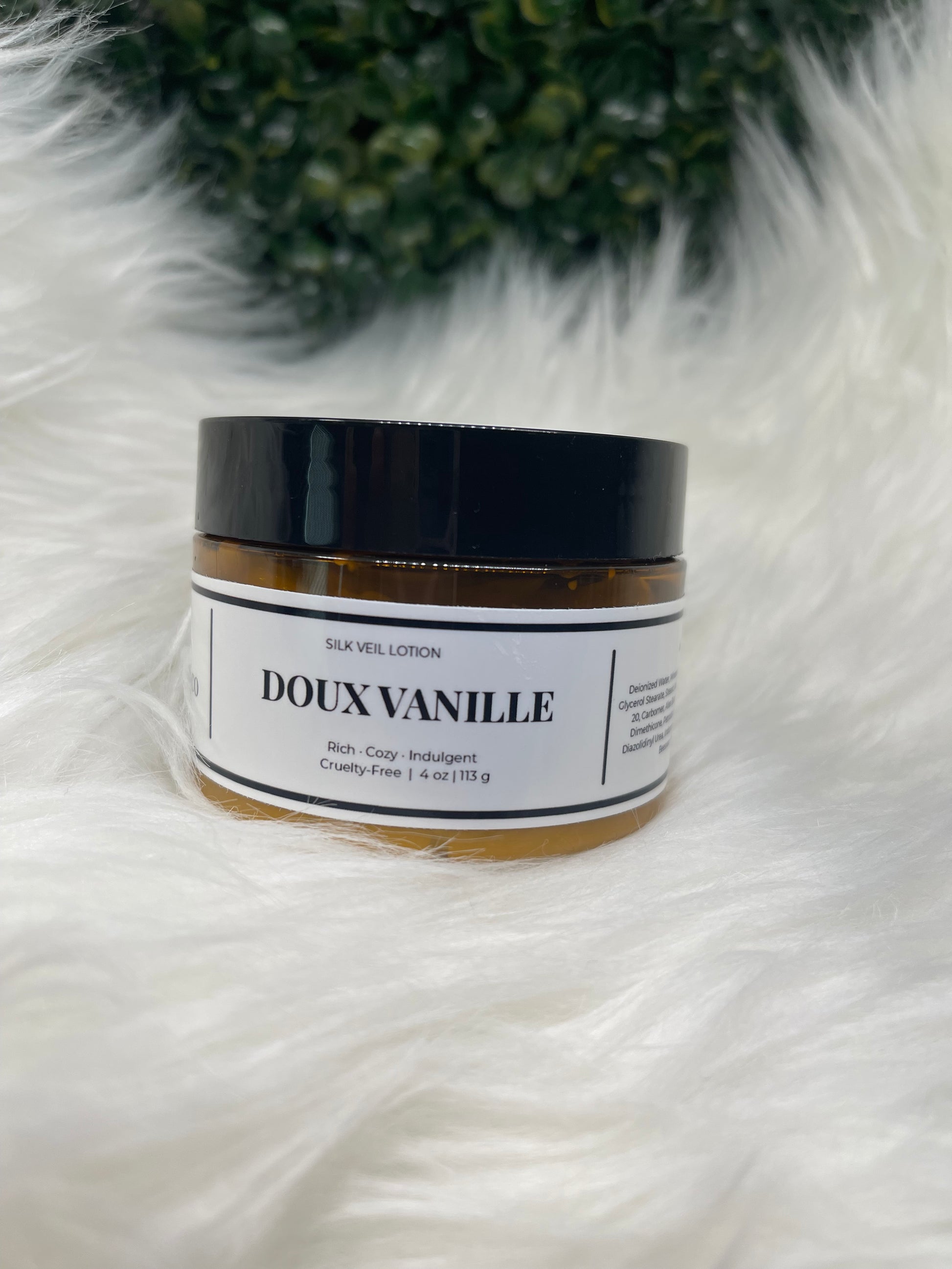 Cosmetic jar with 'DOUX VANILLE' label on a white fur surface