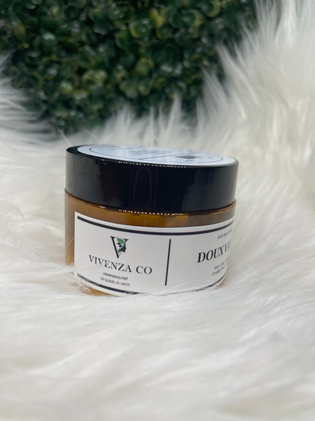 Jar of Vivenza Co. product on a fluffy white surface with greenery in the corner