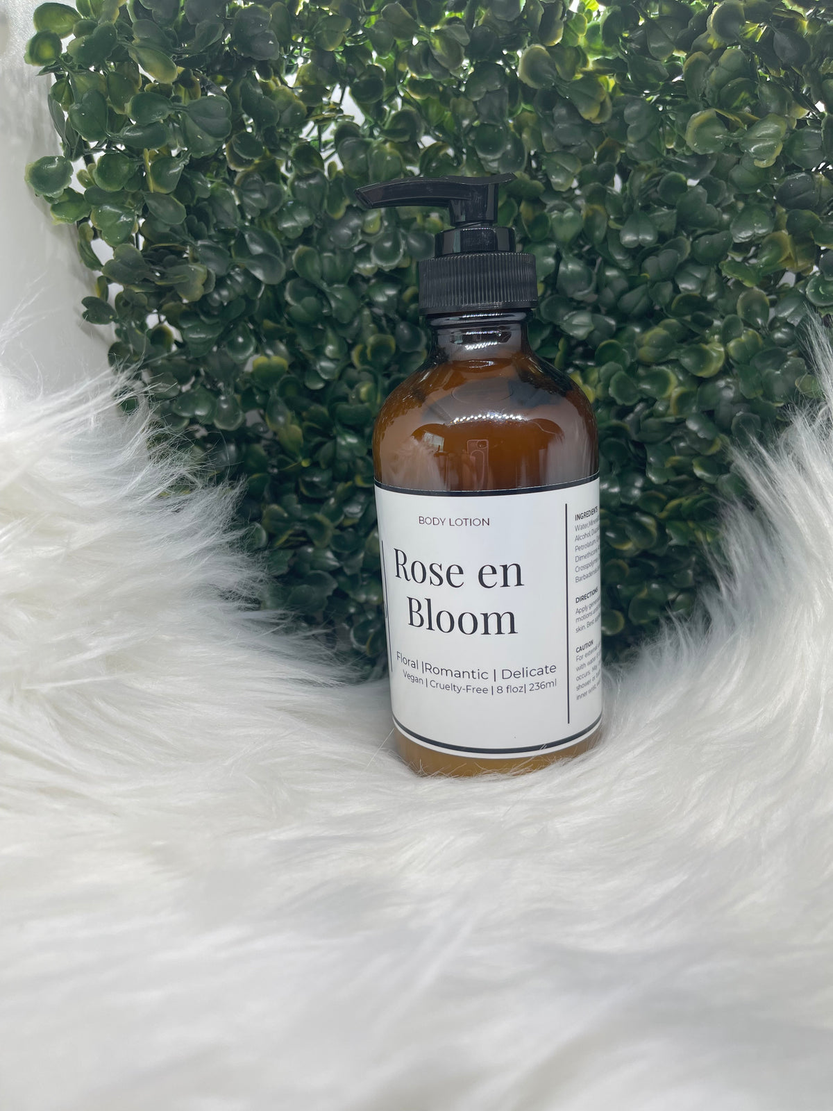Bottle of 'Rose en Bloom' product on a textured green and white surface