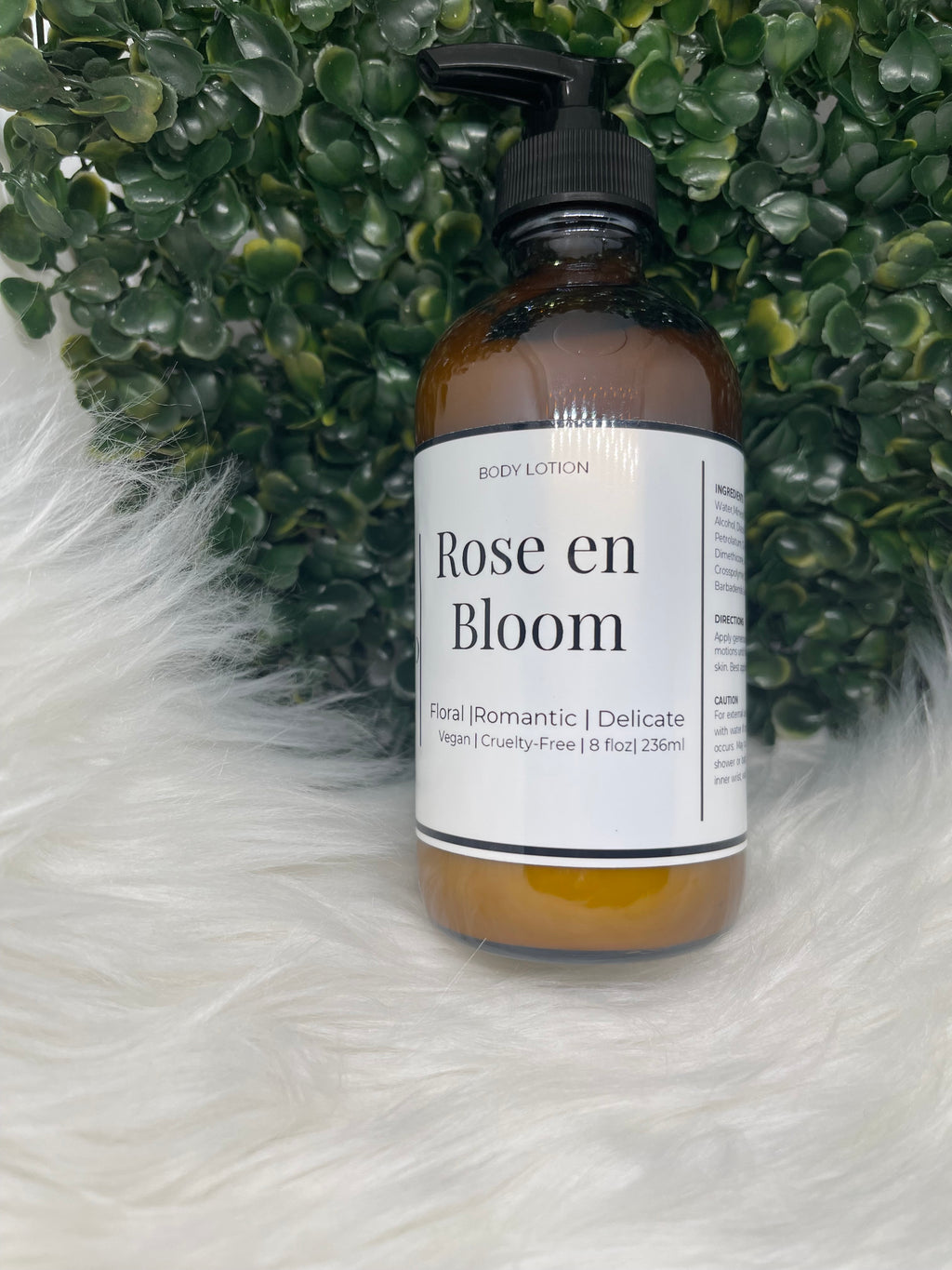 Bottle of 'Rose en Bloom' body lotion with a green leafy background