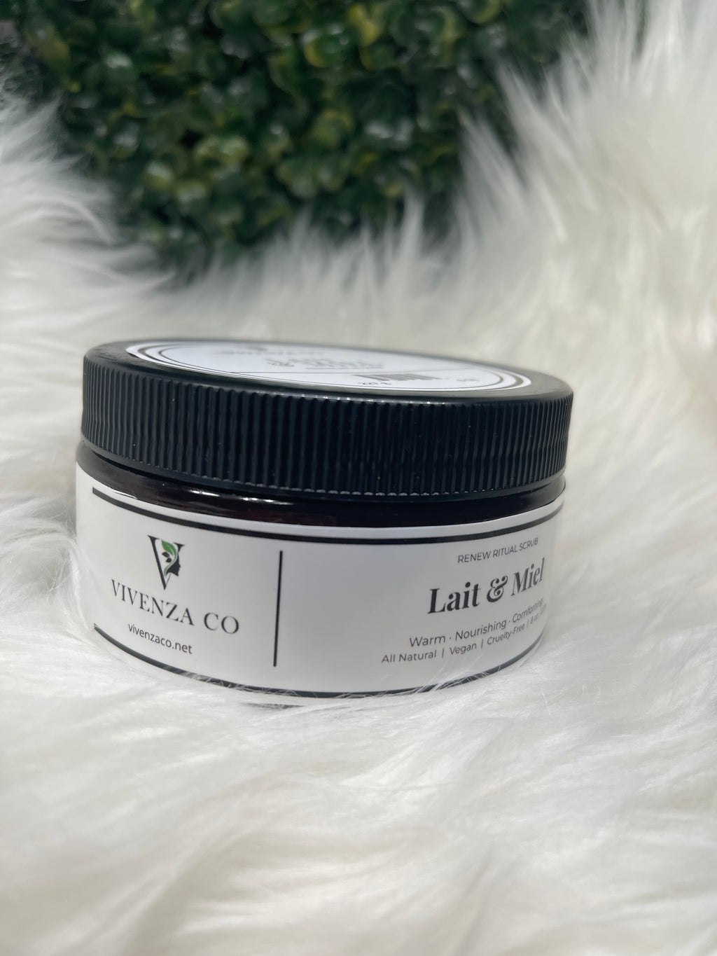 Jar of cream with a black lid on a white fur background