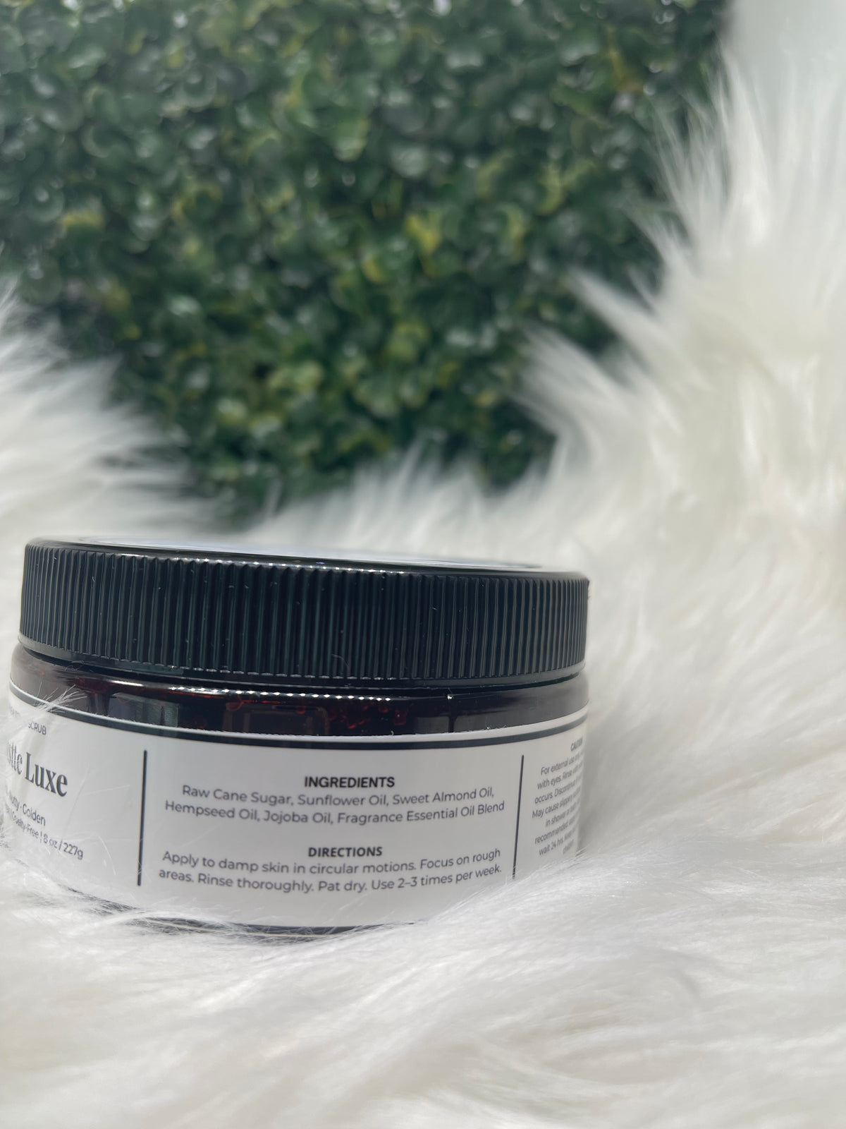 Jar of cream with a label on a fluffy white surface