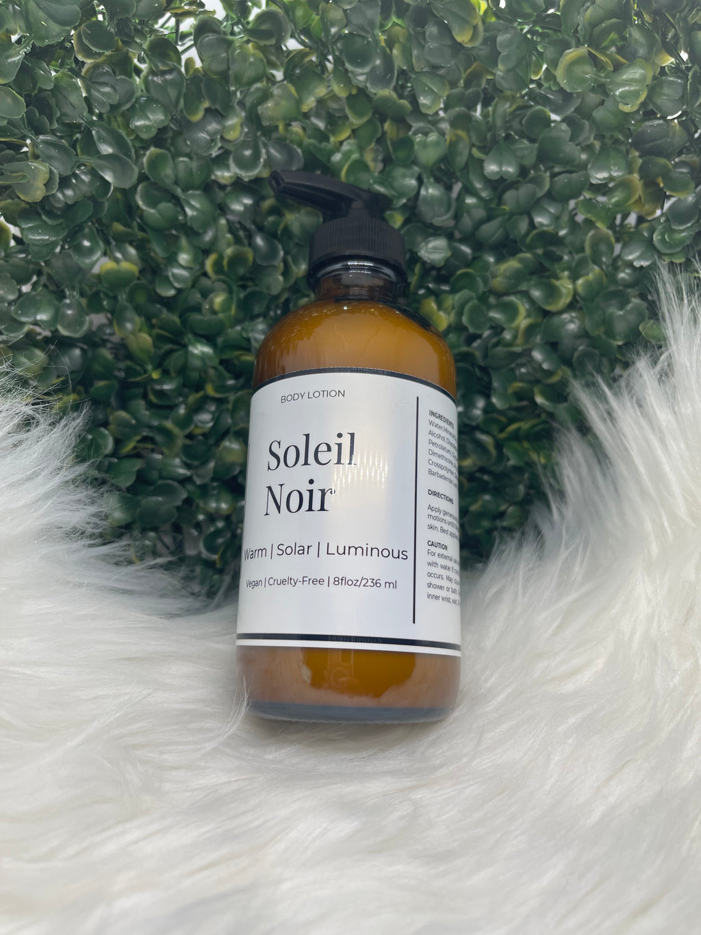 Bottle of 'Soleil Noir' hair product on a textured green and white surface