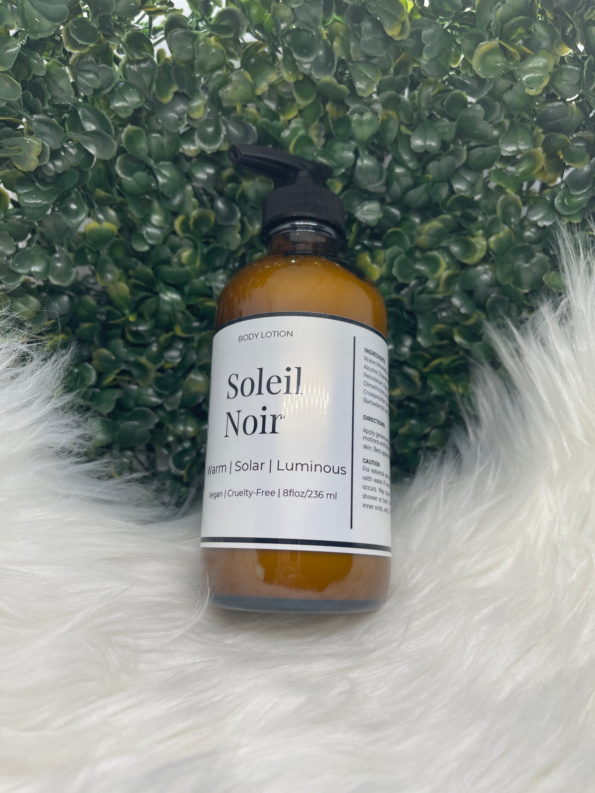 Bottle of 'Soleil Noir' hair product on a textured green and white surface