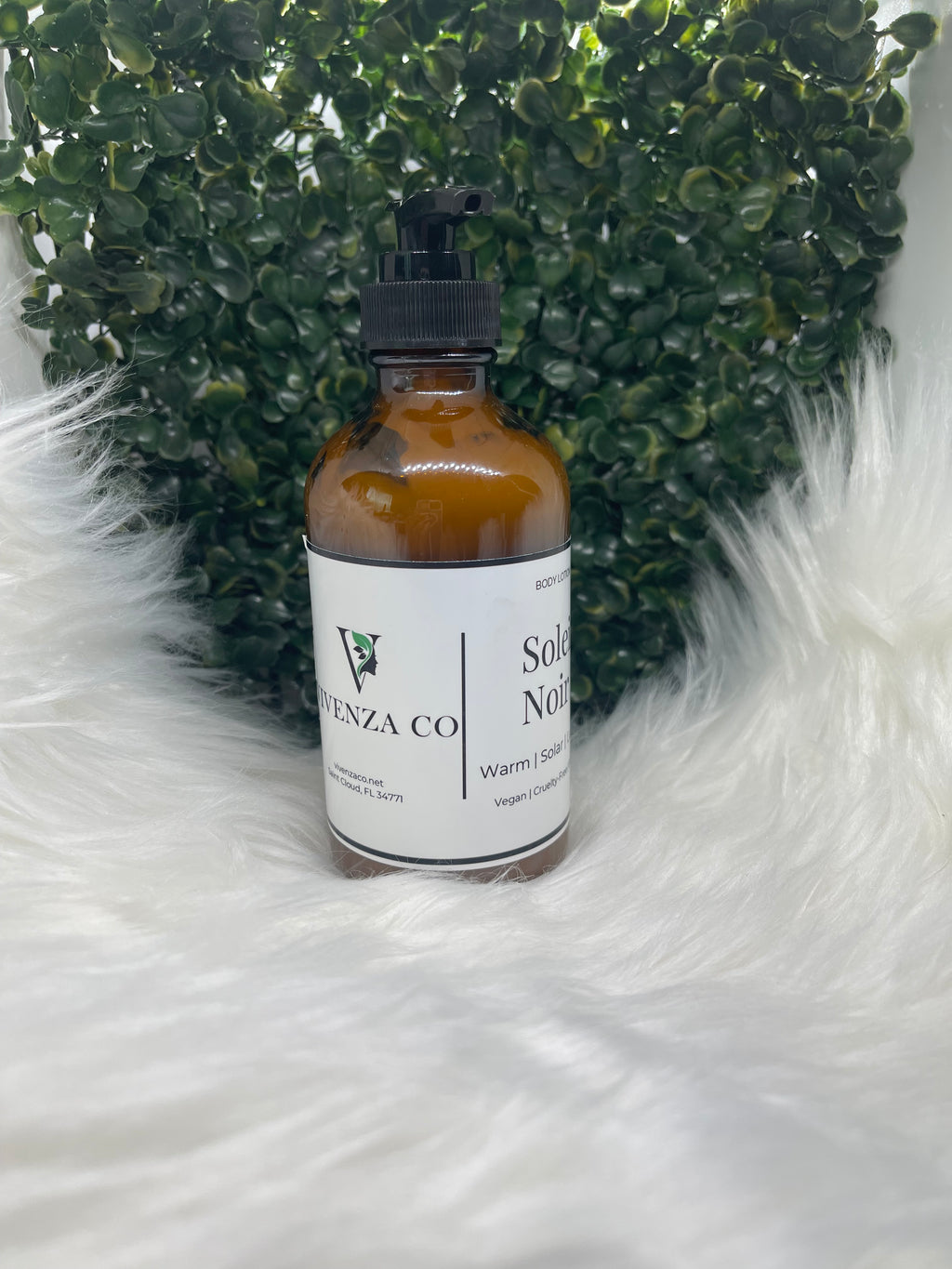 Bottle of VIVENZA Co. product on a textured white surface with green leaves